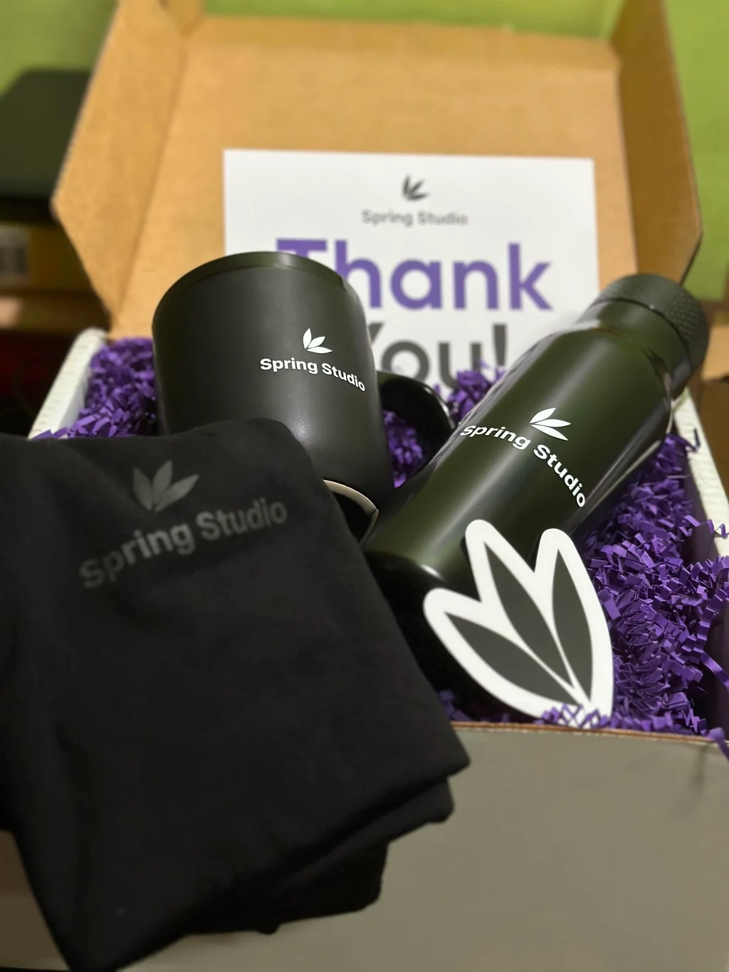 A thank-you note and Spring Studio gear in a welcome box